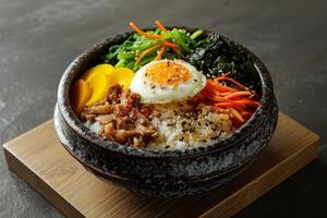 Bibimbap with rice, vegetables and egg in bowl photo