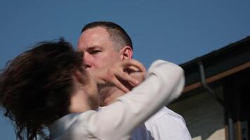 A girl spins under a man's hand. sweetheart in a deserted meadow on a warm autumn day. Close-up view of a young couple kissing in a field with spikelets under the sun, focusing on the girl's face. video