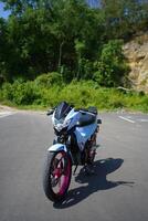 4-Stroke underbone category motorbike that has been modified with a more attractive color than the original. photo