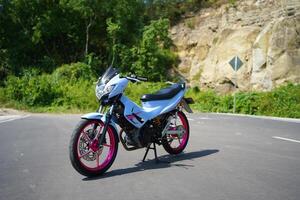 4-Stroke underbone category motorbike that has been modified with a more attractive color than the original. photo