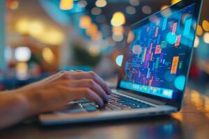 Close-up of hands typing on a laptop with colorful data analytics on screen photo