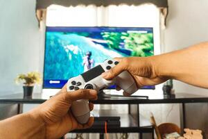 POV of hands using a joystick to play a videogame at home. photo