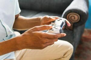 Hands using a joystick to play a videogame at home. photo