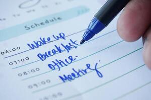 hand with a pen writing to do list on a schedule paper photo