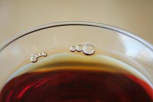Highlighting bubbles on the surface of a drink in a glass container in a closeup view photo
