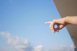 A closeup image of a female hand pointing over water in a natural outdoor setting photo