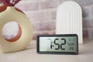 Start your day right by placing a digital alarm clock on a table to wake up in the morning photo