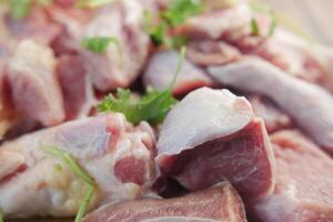 Fresh raw meat cuts displayed on a wooden board with parsley, used for cooking preparation photo