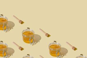 Creative pattern of jar full of natural honey and honeycombs, honey bee and honey dipper on beige background with copy space. Minimal nature concept. Healthy food idea. Honey aesthetic background. photo