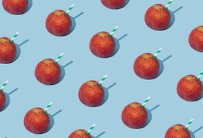 Creative pattern made with juicy peach and green and white drinking straw on light blue background. Minimal summer fruit drink concept. Trendy fresh peach juice idea. Peach juice aesthetic. photo