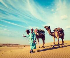 Cameleer with camels in dunes of Thar desert. Raj photo