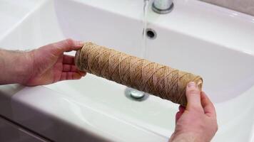 Repairman holds in his hands a dirty water filter. Replacement of the filter in the water purification filter video