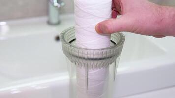 Plumber or repairman puts a new pure white water filter in the bathroom. Replacement of the filter in the water purification filter video