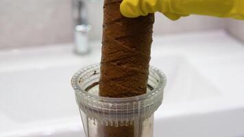 Plumber working replaceable dirty used water filter. Dirty rusty filter for water purification. Multi-stage water filter cartridge replacement video