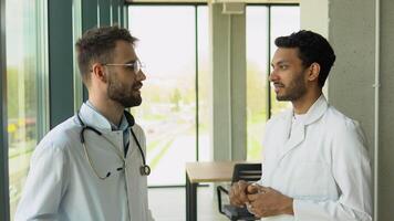 Medical multiethnic staff having discussion in a hospital. Indian and caucasian doctors discussing on laboratory test video