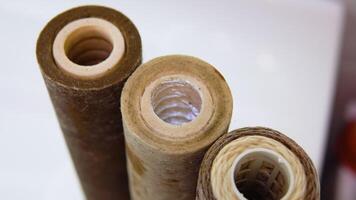 Three used water filters with traces of dirt, clay and contamination spins in the bathroom. Multi-stage water filters cartridge replacement video