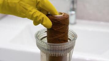 Plumber working replaceable dirty used water filter. Dirty rusty filter for water purification video