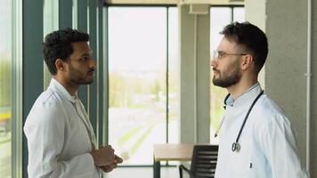 Two multiracial doctors shake hands with each other. The meeting of doctors embraced hands. Greetings from two doctors. Shake each other's hands. An office in a hospital shaking hands video
