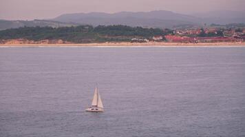 Small yacht with a large river in the background with mountains video