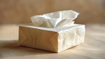 A simple box of tissues placed on a wooden surface, well-lit and minimalistic. photo