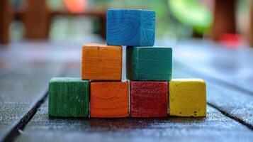 Pyramid of colorful wooden toy blocks arranged on a table, representing creativity and play. photo