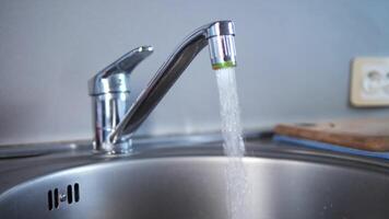 Close-up of faucet and a jet of water pouring into the sink. Observe the steady flow from the faucet, showcasing the clarity and force of water. The faucet provides a consistent and powerful stream. video
