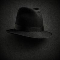 A sophisticated black fedora hat adorned with delicate raindrops, set against a dark background. This image captures the essence of mystery and elegance, making it ideal for noir aesthetics, fashion photo