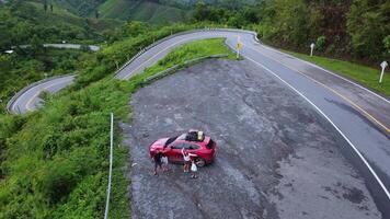 Aerial view of parked cars and tourists enjoying the beautiful view of the road in the middle of the mountain forest. Bird's eye. Travel concept. video