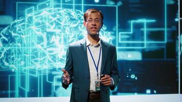 Presenter talking in front of world leading technology specialists and researchers meeting at artificial intelligence conference. Data scientist showcasing latest innovations in AI industry, camera A video