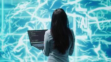 Computer scientist working on laptop, programming artificial intelligence computing simulating human brain. Woman using notebook, developing AI machine learning algorithms, camera A video