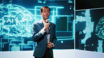 Presenter talking with spectators at AI convention bringing together IT specialists, sharing insights from latest developments in artificial intelligence and cognitive computing, camera A video