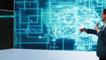 Tech company CEO using summit as platform to launch latest AI products. Manager uses mic to talk at forum to connect with business leaders and investors interested in artificial intelligence, camera A video