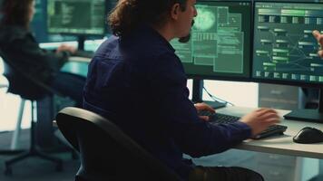 Cyber security experts in a governmental hacking room working on securing networks. Hackers focusing on malware detection, cyber operations and protection against digital mercenaries. Camera A. video