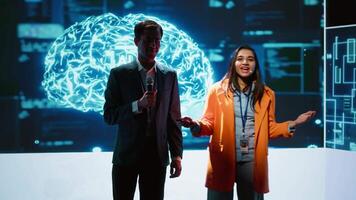 Tech specialists discussing during keynote summit presentation, exploring successful implementation of AI in driving forward businesses, sharing latest artificial intelligence innovations, camera A video
