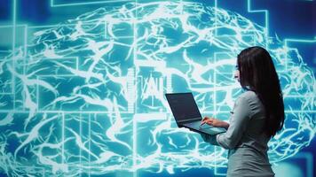 Computer scientist working on laptop, programming artificial intelligence computing simulating human brain. Woman using notebook, developing AI machine learning algorithms, camera B video