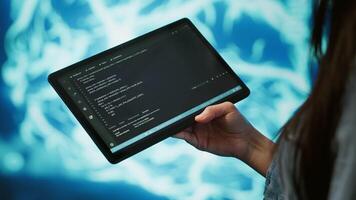 Programmer using tablet to maintenance artificial intelligence neural networks. Close up shot of computer scientist using AI system aiding in processing and transmitting information, camera A video