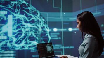 AI computer scientist using laptop for business data analysis in high tech workspace. Close up shot of Indian woman working on notebook to automatize tasks using artificial intelligence, camera B video