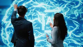 Engineer wearing VR headset and coworker working with artificial intelligence neural networks. Colleagues using virtual reality technology and AI system in high tech workspace, camera A video