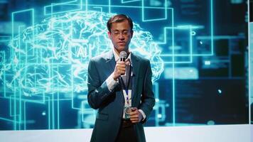 Speaker does presentation during tech conference, exploring successful implementation of AI in driving forward startup businesses, sharing latest machine learning discoveries, camera A video