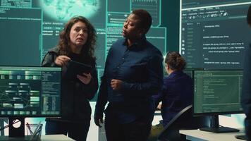 Cyber security experts women working on spyware and malware detection in a governmental agency. Examining server information on a big screen to combat cyberterrorism and cyberwarfare. Camera A. video