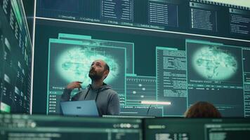 Governmental hacker examines info on a big screen in agency office, using advanced technology to secure computer networks. Working on cyber security and defending against cyberwarfare. Camera B. video