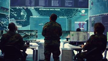 Woman colonel handling a special operation with big data in monitoring room, providing important satellite information to her crew in command post. Targeting enemy power base. Camera B. video