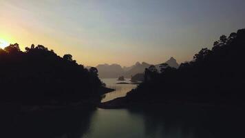 A beautiful landscape with a lake and mountains in the background. The sky is a mix of orange and blue hues, creating a serene and peaceful atmosphere video