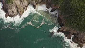 A beautiful ocean view with a rocky shoreline. The water is calm and the sky is clear video