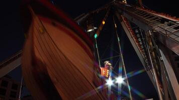 Nighttime Amusement Park Ride in Motion, Capturing Swings of Giant Swing Ride with Illuminated Lights Against Dark Sky, Emphasizing Fun and Thrill of Carnival Atmosphere video