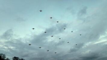 Formation of drones against a cloudy sky. Multiple drones fly in a synchronized formation against a backdrop of a cloudy sky. video
