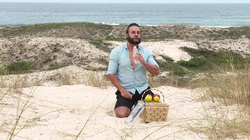Man eating fruit and drinking water during picnic on the beach. Frontal Camera. video