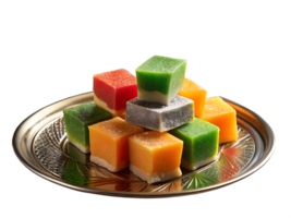 Colorful pieces of barfi garnished with silver leaf, set on a decorative plate with a cup of chai, isolated on background png