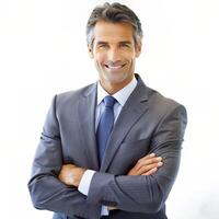 Smiling male professional standing with arms crossed while making eye contact against isolated background photo