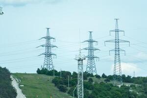 High voltage towers with sky background. Power line support with wires for electricity transmission. High voltage grid tower with wire cable at distribution station. Energy industry, energy saving photo